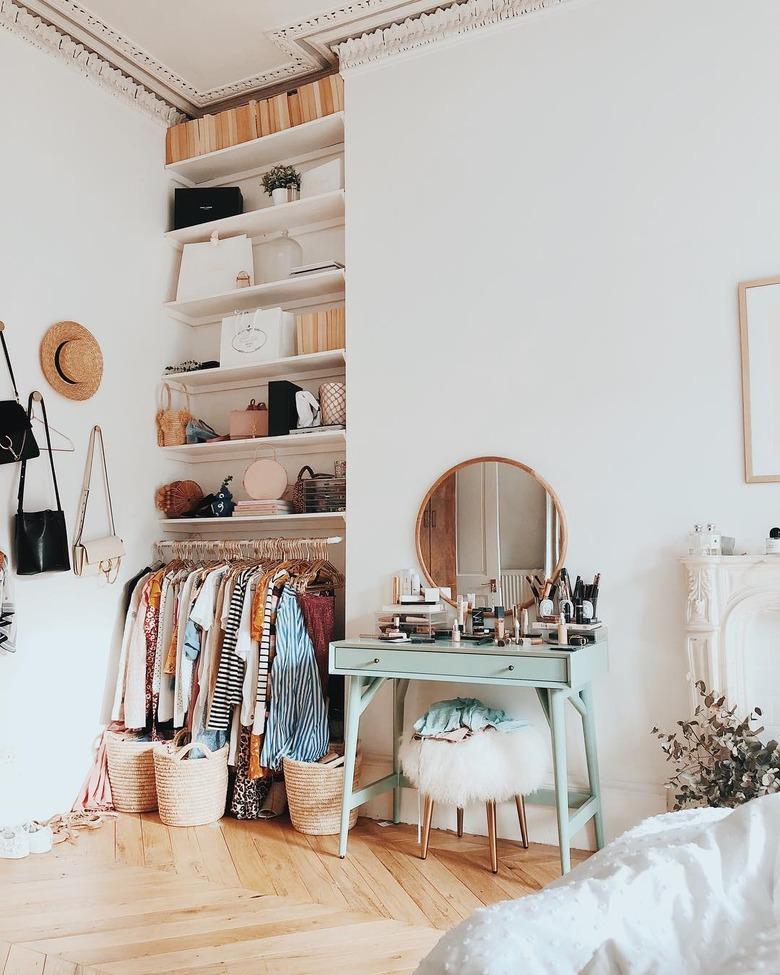 corner bedroom layout idea with exposed closet storage with mint green vanity