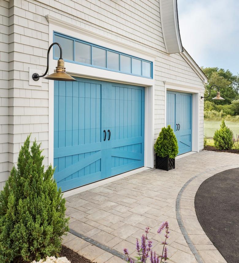 Exterior Garage Lighting on white farmhouse exterior with brass bell style pendant