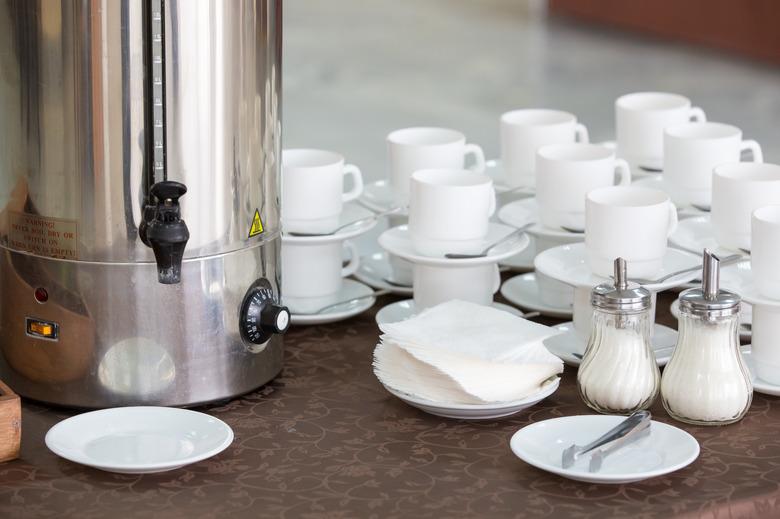 silver tea urn, white cup and saucer and sugar bowl