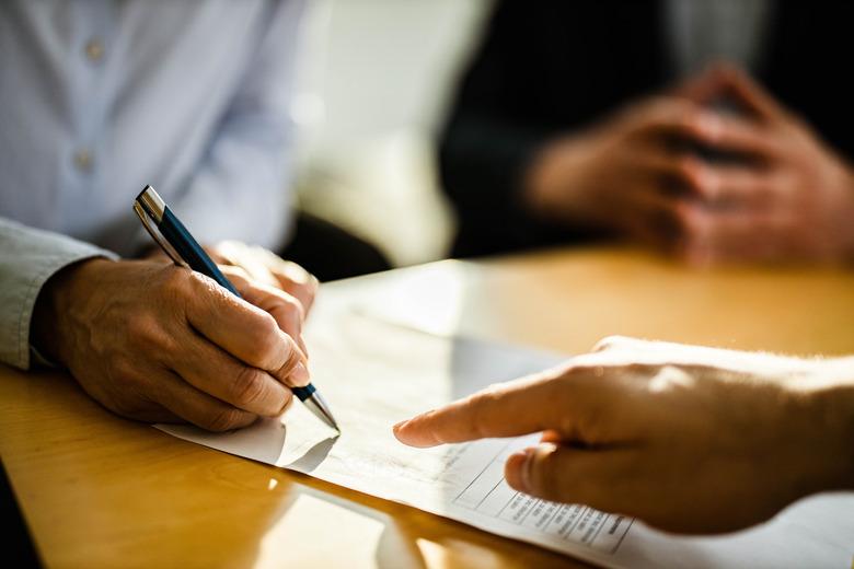 Close up of unrecognizable person signing a contract.