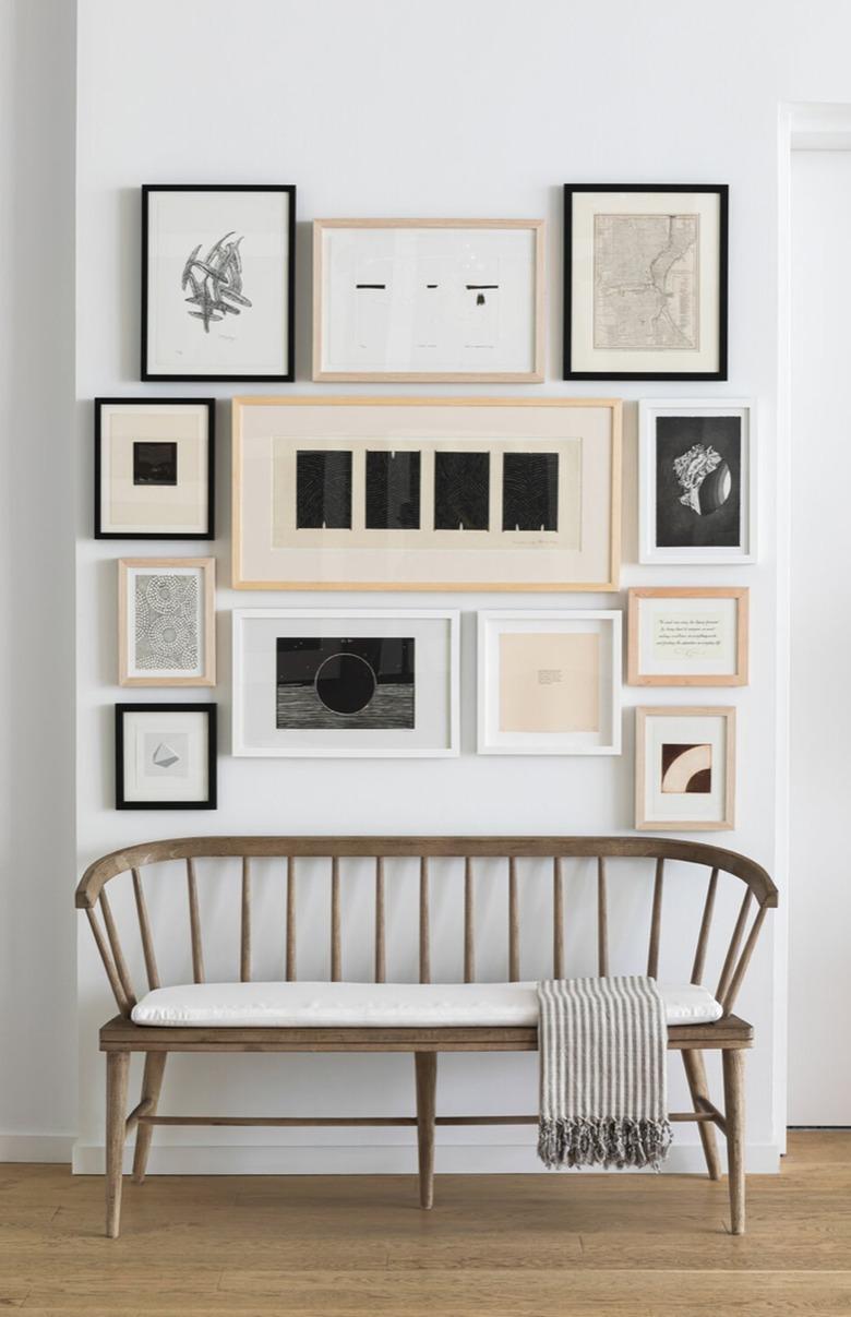 Entryway with gallery wall, wood bench.