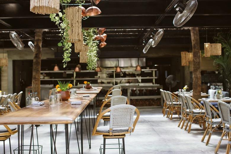 Outdoor dining area with wood tables and rattan chairs