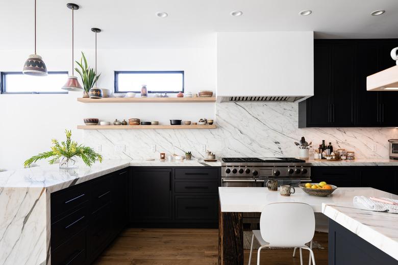 large kitchen with marble countertop and white walls