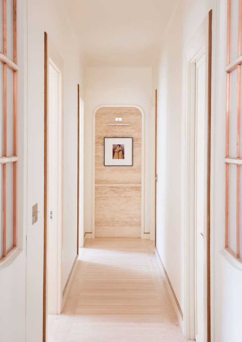 White Modern Hallway with light wood floors, art.