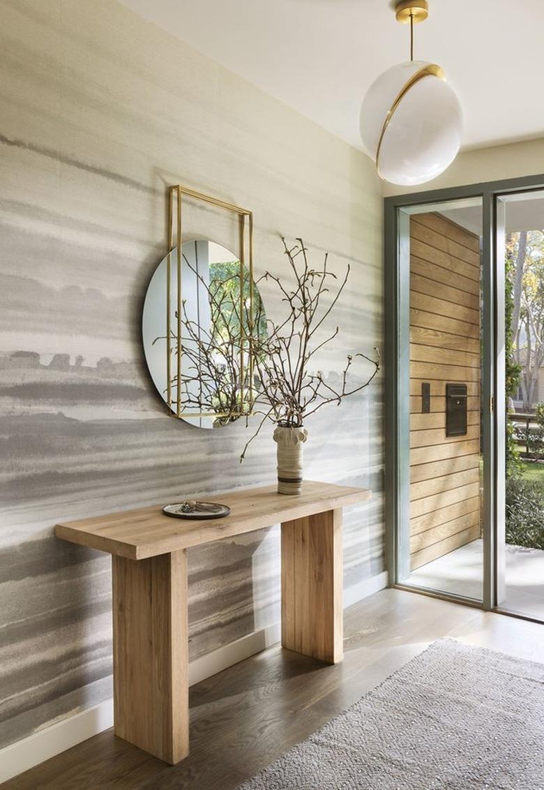 Modern Hallway with console table, mirror, wallpaper, globe lamp.