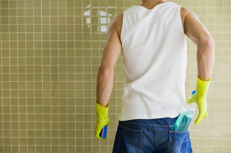 Man cleaning shower wall