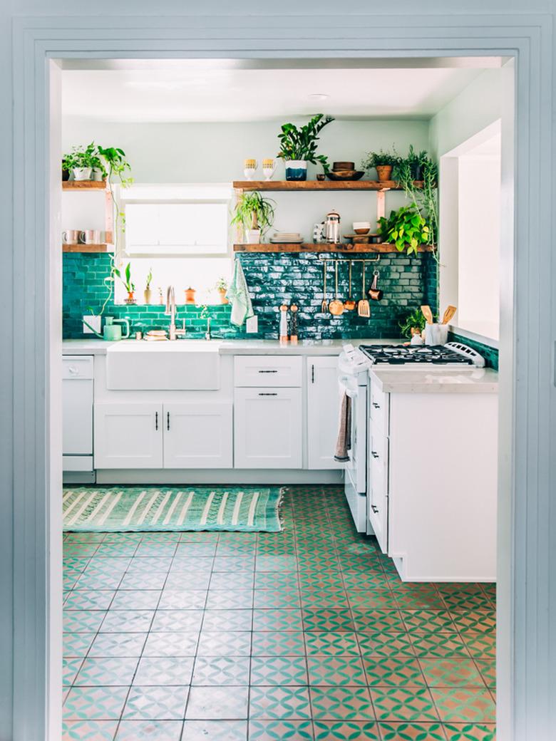 Moroccan kitchen floor tiles in green pattern with green backsplash and white cabinets