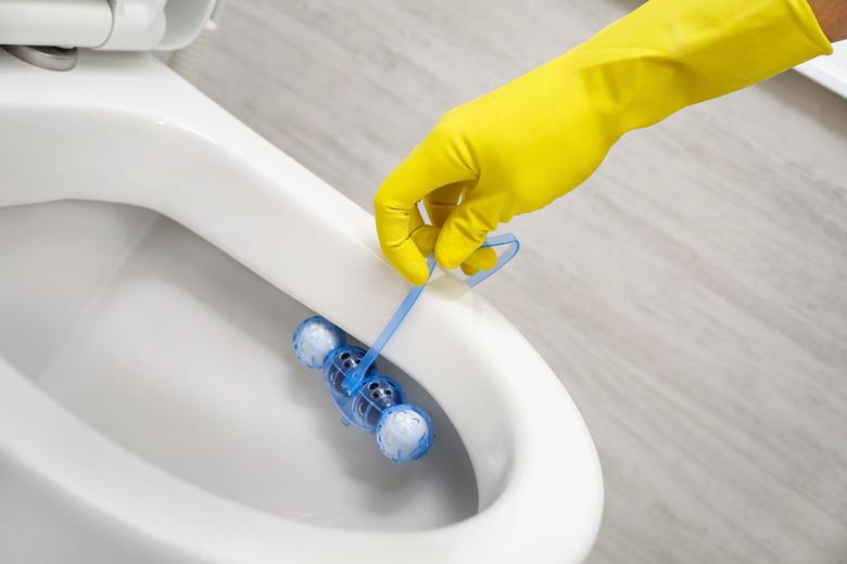 Putting toilet balls cleaner in toilet bowl