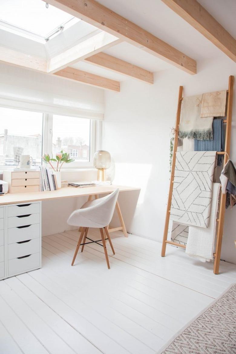 neutral home office with modern desk and blanket ladder