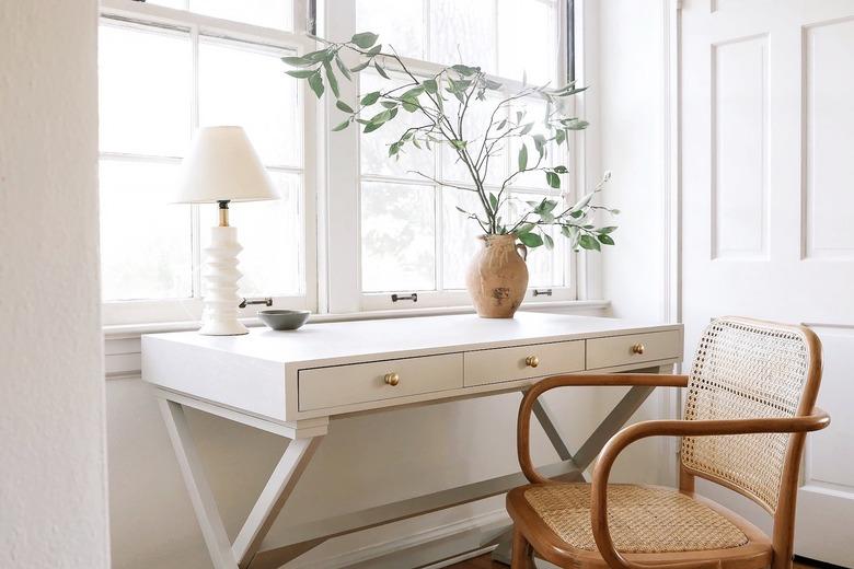 white desk with geometric white lamp and vintage wood chair