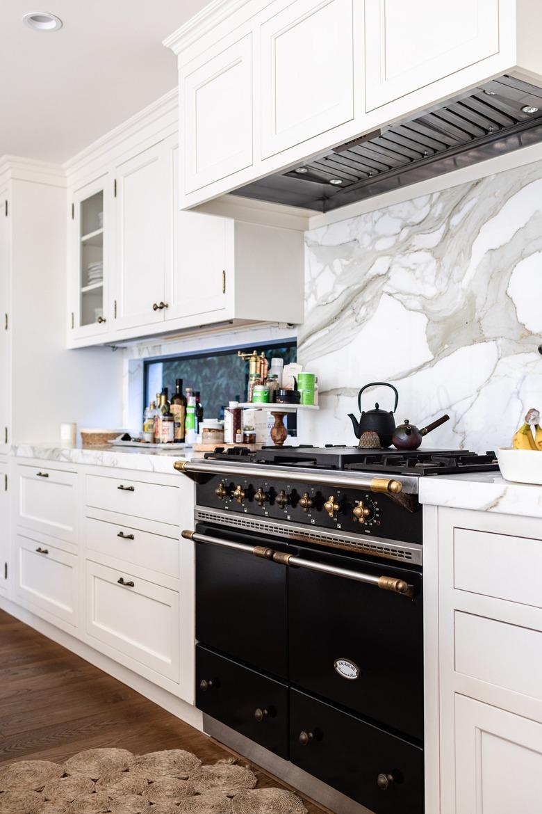 classic black and gold gas new stove with marble backsplash