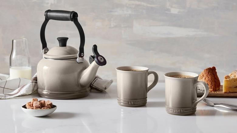 Le Creuset teapot and two mugs on a counter