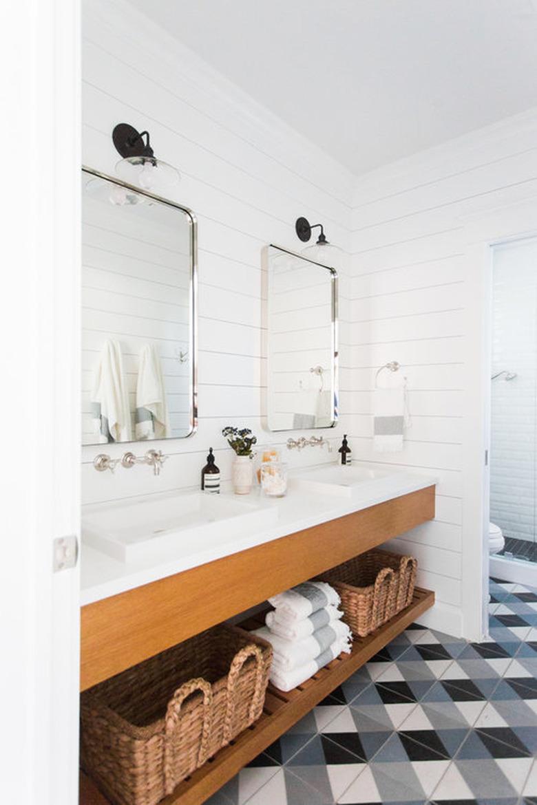 farmhouse style bathroom space with a long vanity and checkered floor