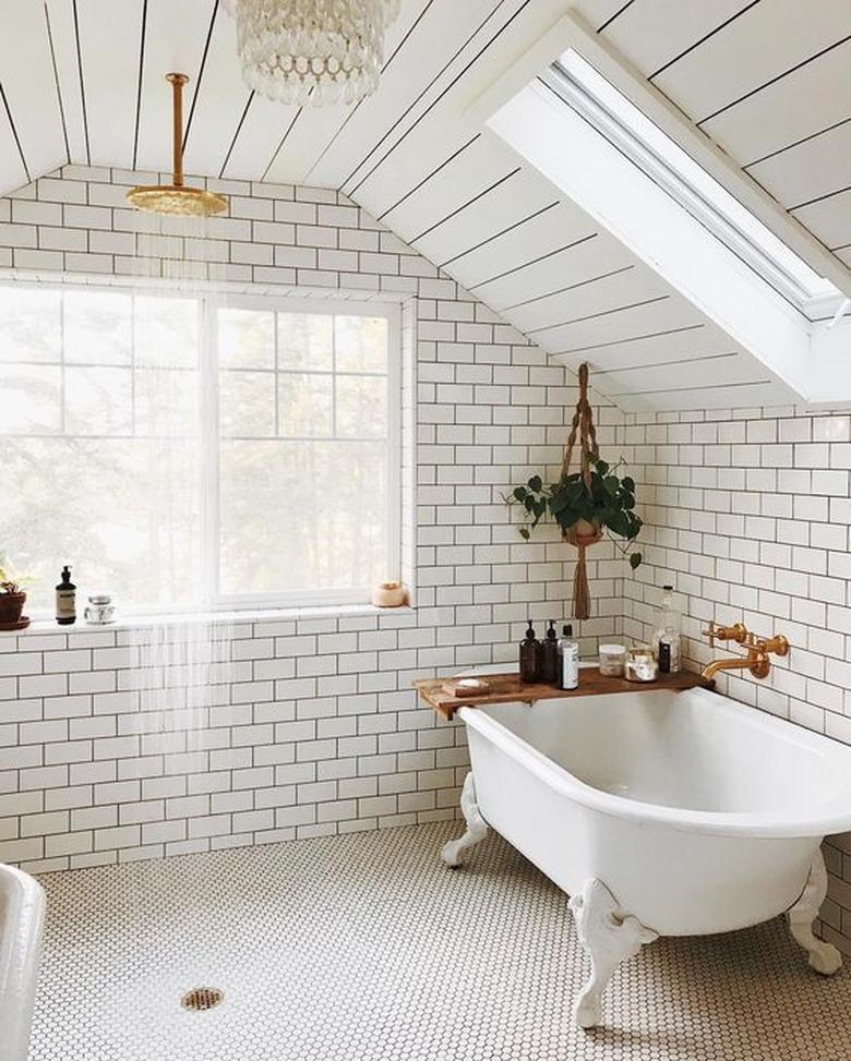 simple white boho bathroom with open shower and hanging botanicals