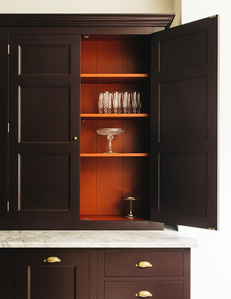 Kitchen cabinets with orange painted on the inside