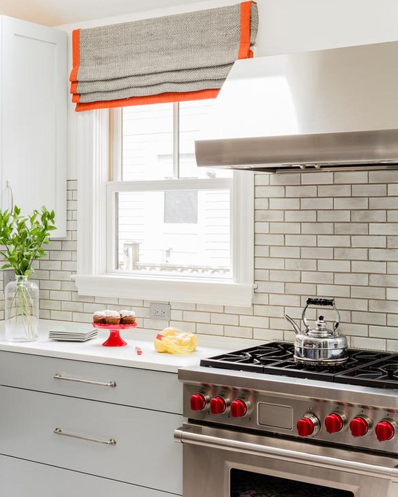 Kitchen with orange trimmed window treatments