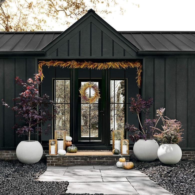 black home with wheat garland hung above the threshold