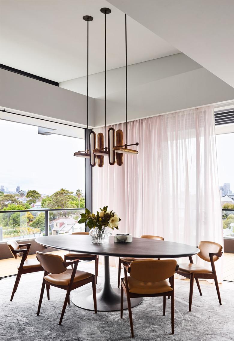 pink dining room with blush sheer drapery and oval table