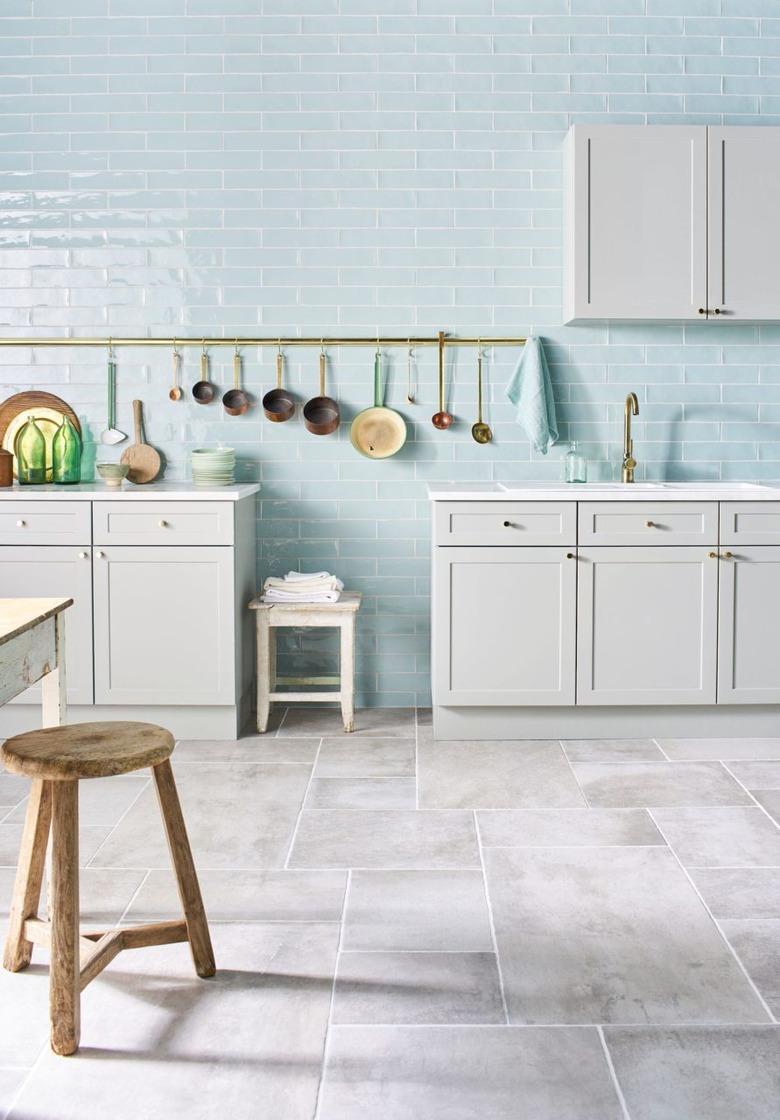 kitchen space with blue walls and white cabinets with light porcelain flooring