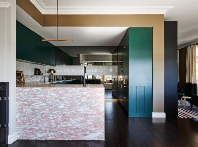 Pink quartz countertop colors, teal cabinets, and dark wood floors