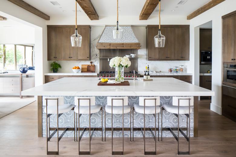 wood kitchen cabinets with white countertops and large island