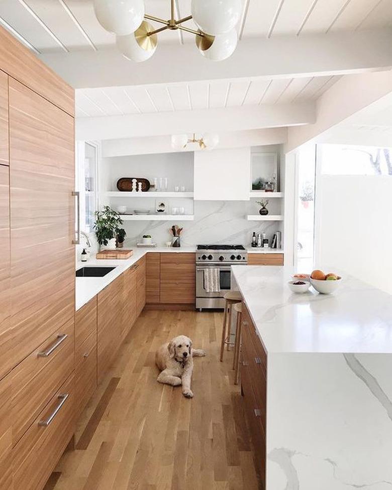 midcentury kitchen lighting idea with wood cabinets ant marble backsplash and countertops