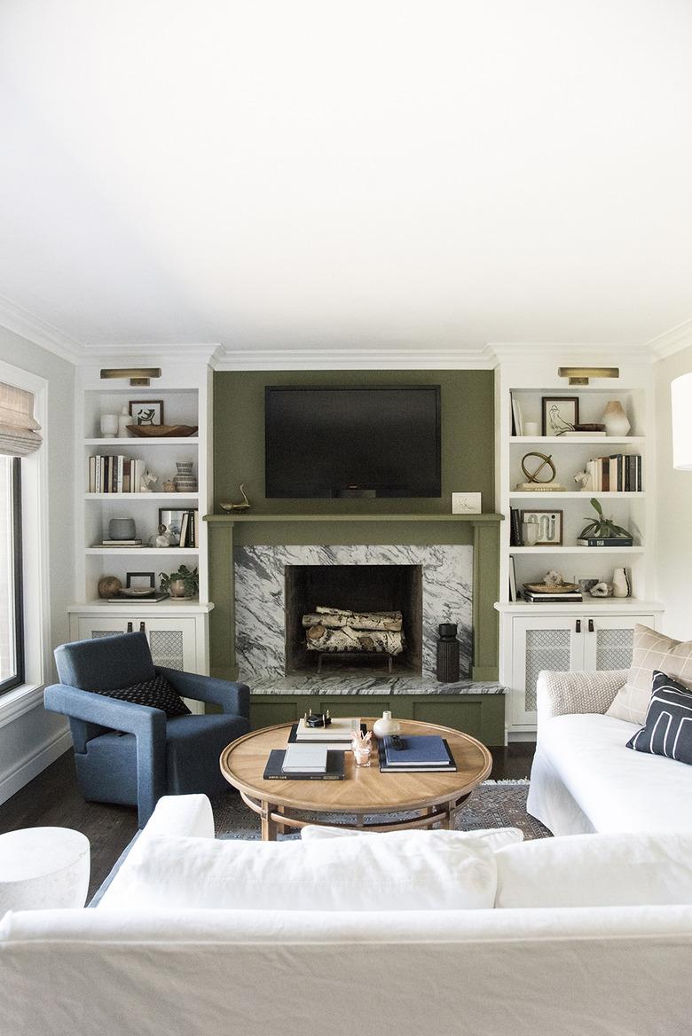 rustic family room ideas with green accent wall and marble fireplace