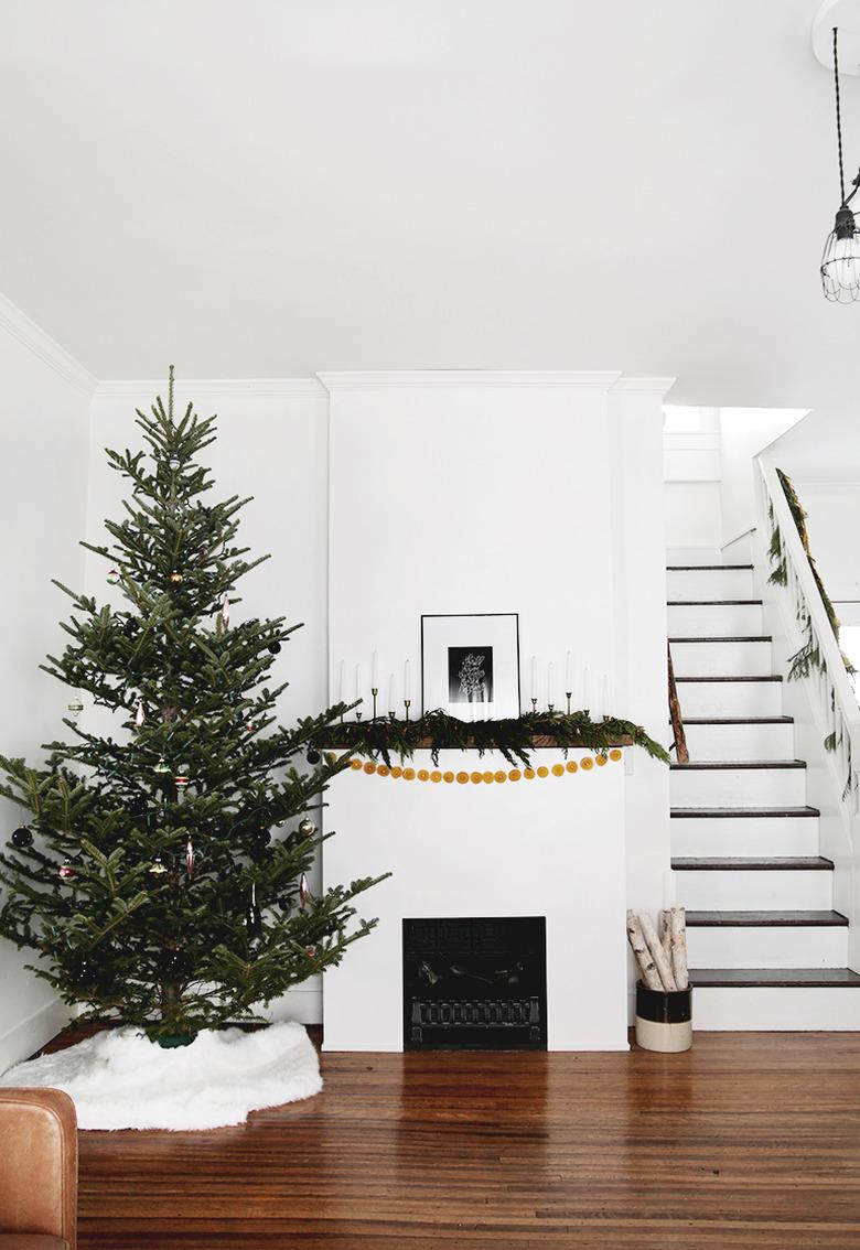 white living room with Scandinavian Christmas tree  and fireplace