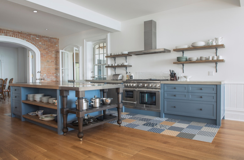 Scandinavian kitchen floor tile in patchwork pattern with blue cabinets