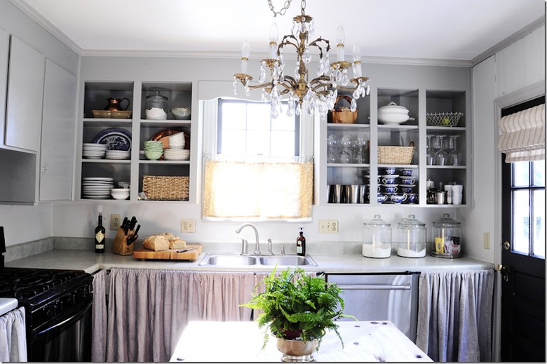 Neutral gray kitchen with chandelier and open cabinets.