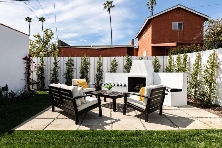 outdoor space with sofa and armchairs facing a fire pit