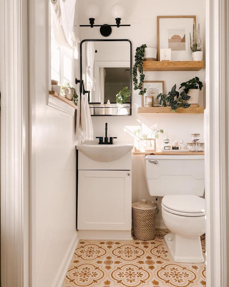 small bathroom wall art with stenciled floor and floating shelves