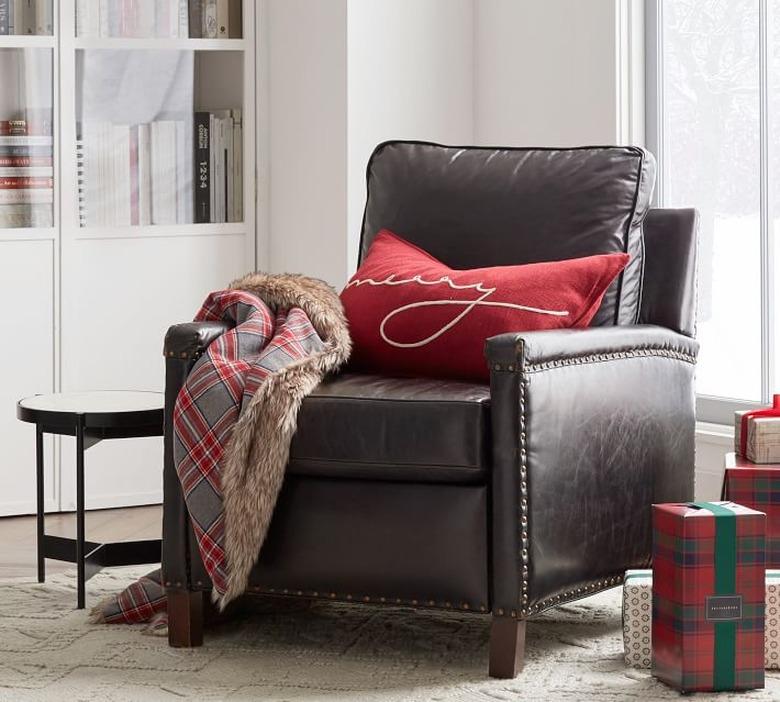 chair with red pillow and plaid throw blanket