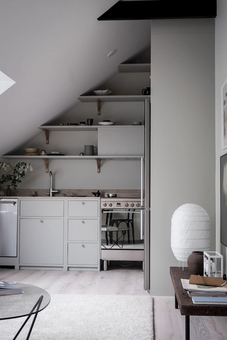 All gray kitchen with stainless steel electric stove and dishwasher, open shelves.