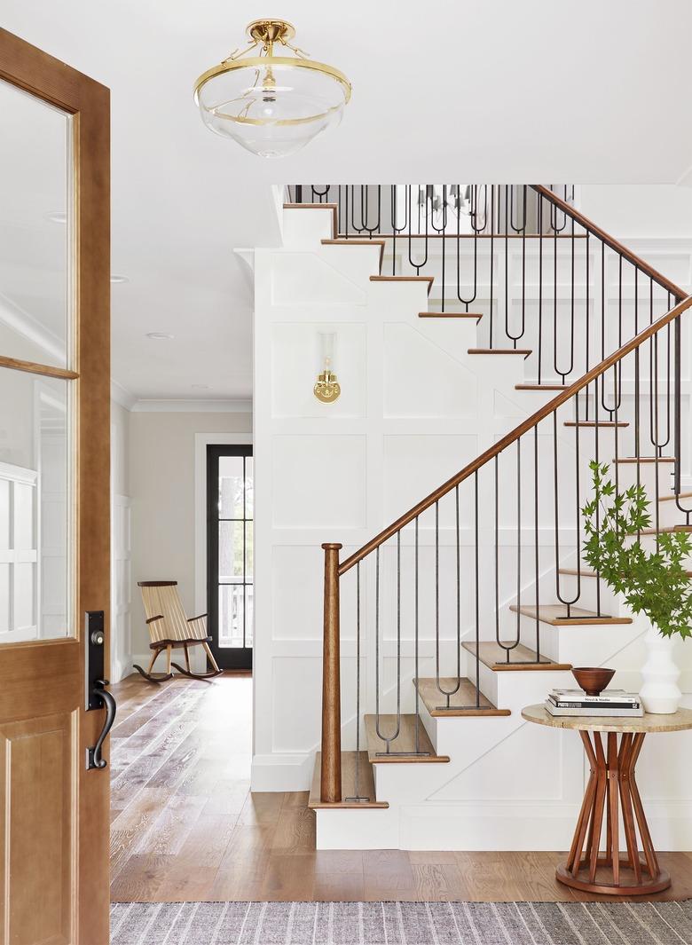 traditional staircase with metal spindles and wood stair railing