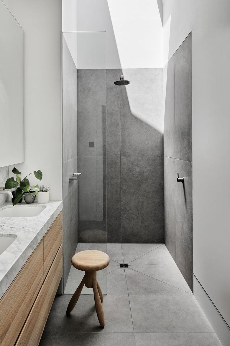 stone tile bathroom with Carrara marble and wood details