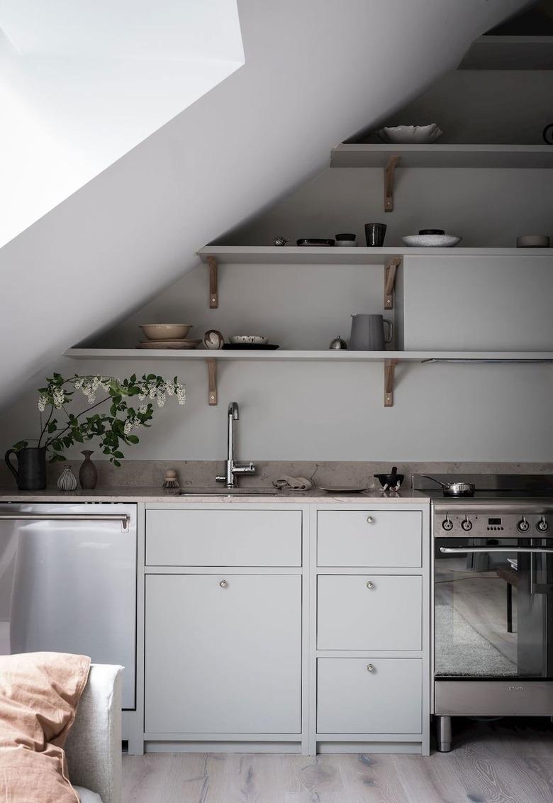 simple and modern kitchen with grey cabinets and open shelving