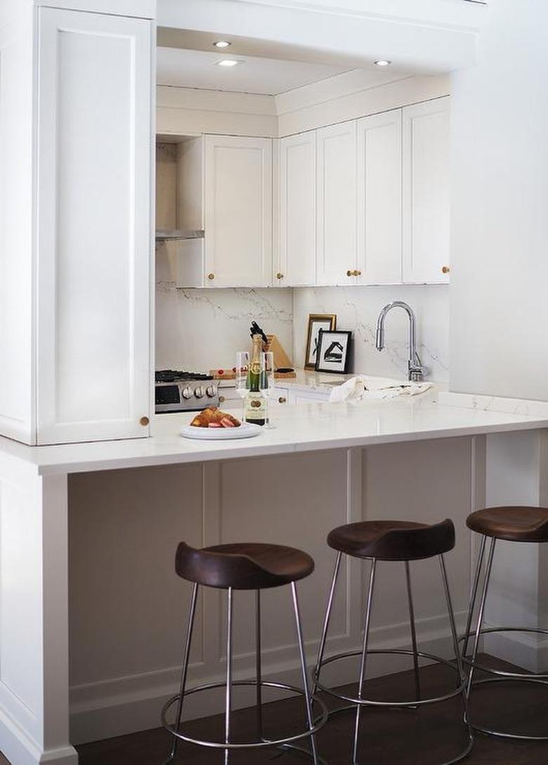 white apartment kitchen with brass hardware