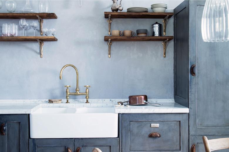 blue farmhouse kitchen with open shelving and double sink with gooseneck faucet