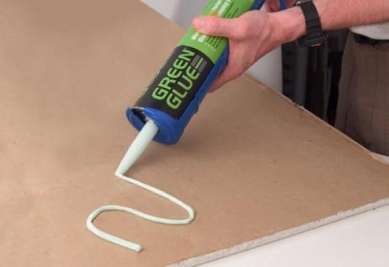 Applying Green Glue to drywall.