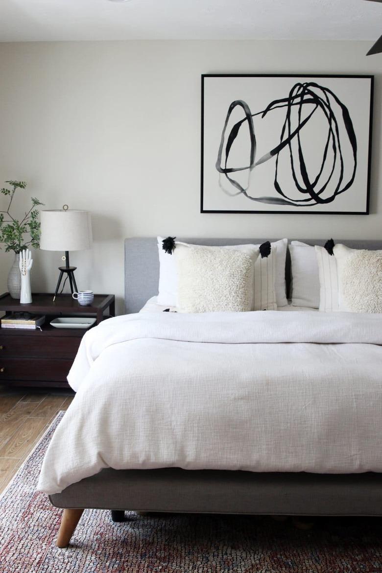 Bedroom with a neutral color scheme an well-chosen abstract art