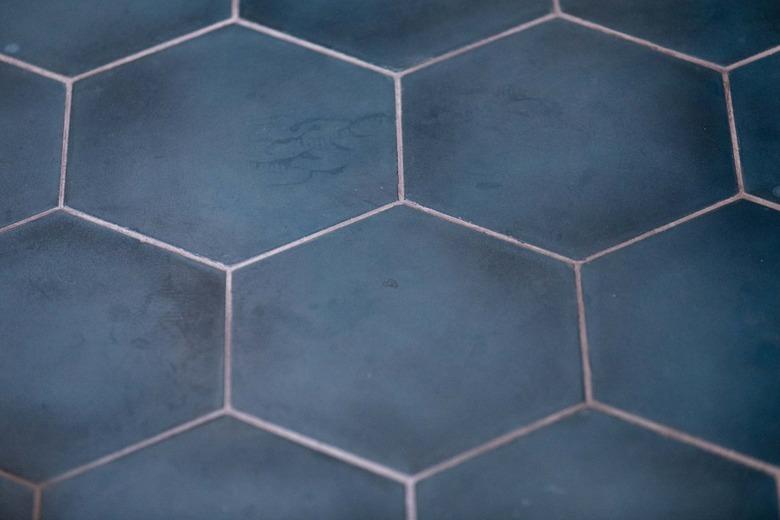 A close up shot of clean, navy blue, hexagonal tile in a bathroom