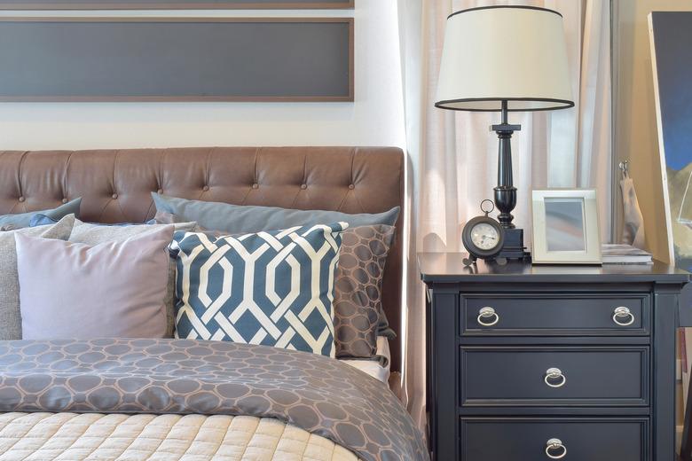 Cozy bedroom interior with pillows and reading lamp