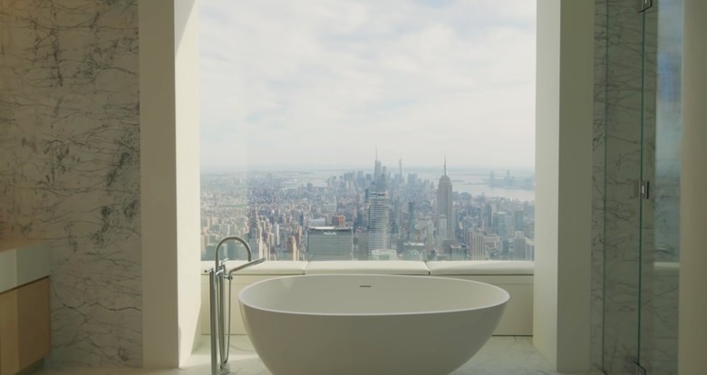 Bathtub in a penthouse facing a window overlooking New York City