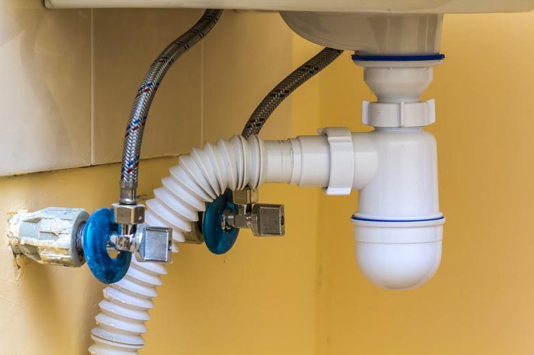 Sewer drain pipes under the kitchen sink.Plumbing fixture and faucets