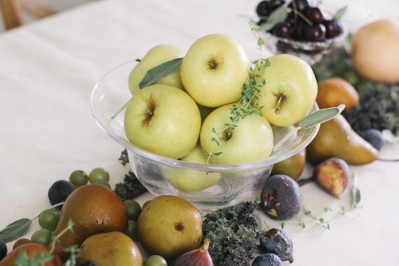 a clear bowl of apples forms the centerpiece for a table with an edible runner