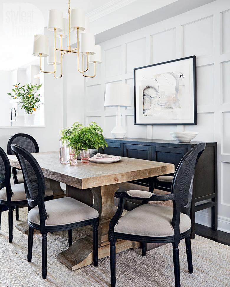 traditional dining room lighting with chandelier above table with black chairs