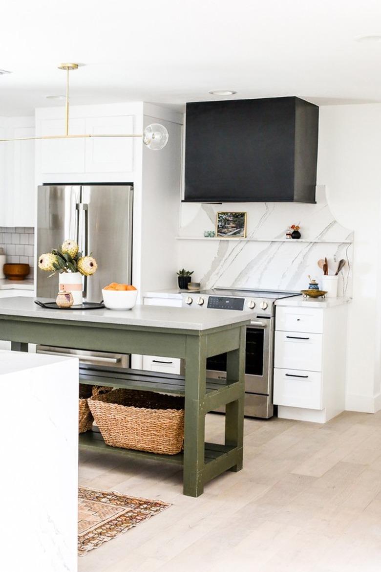 green traditional kitchen island in kitchen with marble backsplash