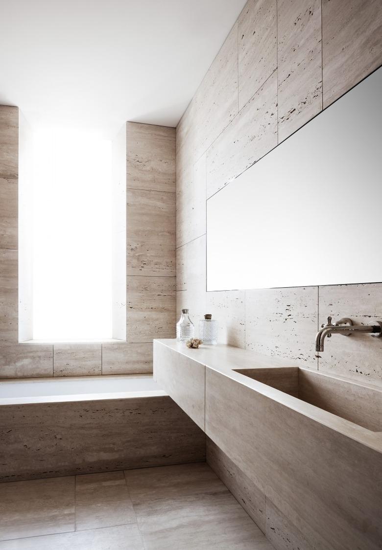 Floor to ceiling travertine bathroom with minimalist accents