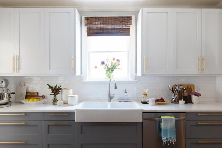 kitchen space with white and dark gray cabinets and white sink